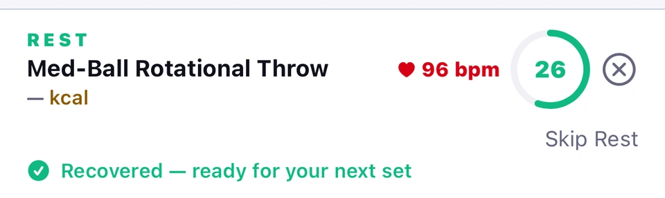 The rest ribbon after a set of Med-Ball Rotational Throw: REST, heart rate 96 bpm, a dash for calories, 26 seconds left on the ring with Skip Rest under it, and the green line Recovered — ready for your next set.