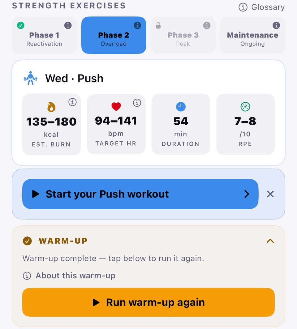 The Plan tab right after a warm-up: the phase tiles with Phase 2 · Overload selected, the Wed · Push targets card, the blue Start your Push workout banner with an ✕ beside it, and the warm-up card reading Warm-up complete — tap below to run it again, with a Run warm-up again button.